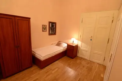 a small bedroom with a bed and a night stand at Pension Karlova in Prague