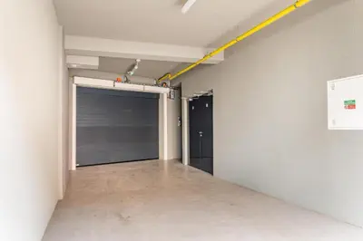 an empty garage with a garage door and a yellow line on the wall at Brand new studio apartment #50 FREE PARKING close to center in Prague