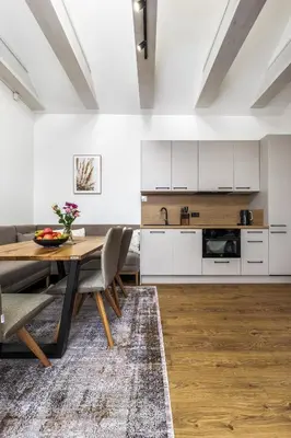a kitchen and dining room with a table and chairs at Apartmán Rezidence Malá Louka in Kublov