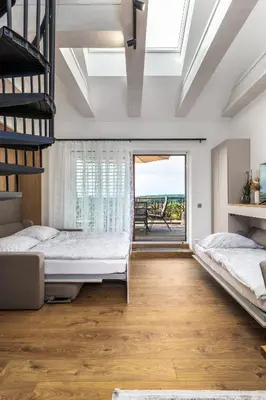 a bedroom with two beds and a balcony at Apartmán Rezidence Malá Louka in Kublov