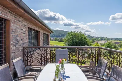 a table and chairs on a balcony with a view at Apartmán Rezidence Malá Louka in Kublov