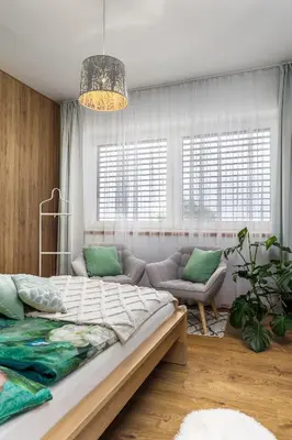 a bedroom with a large bed and a couch at Apartmán Rezidence Malá Louka in Kublov