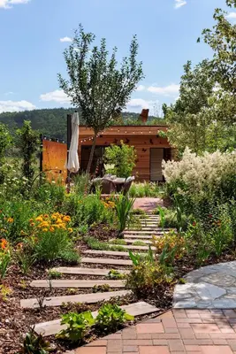 a garden with a stone path in front of a house at Apartmán Rezidence Malá Louka in Kublov