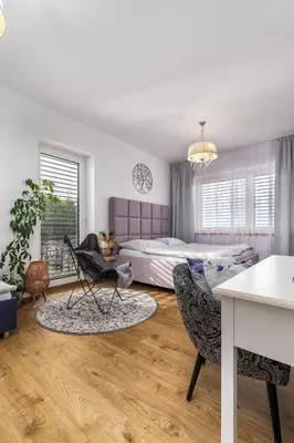 a bedroom with a bed and a table and chairs at Apartmán Rezidence Malá Louka in Kublov