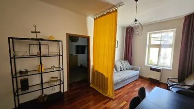 a living room with a couch and a yellow curtain at Zizkov Apartment in Prague