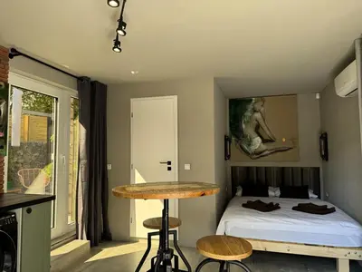 a bedroom with a bed and a table in a room at Garden Residence - The Garage in Drahobudice
