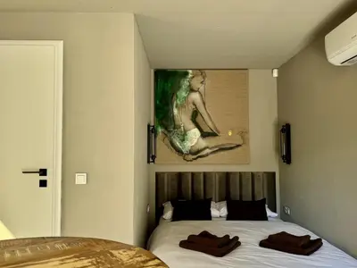 a bedroom with a bed with a painting on the wall at Garden Residence - The Garage in Drahobudice