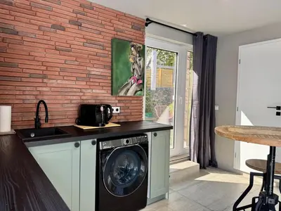 a washing machine in a kitchen with a brick wall at Garden Residence - The Garage in Drahobudice