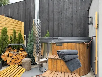 a hot tub with towels on a wooden deck at Garden Residence - The Garage in Drahobudice