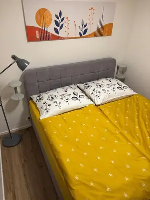 a bed in a room with a yellow blanket at Apartment Vyšehrad in Prague