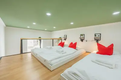 two beds in a room with red pillows at HOMELY I Central 28m2 loft I ELEVATOR I Self Check-In in Prague