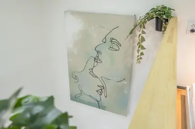 a painting hanging on a wall with a plant at HOMELY I Central 28m2 loft I ELEVATOR I Self Check-In in Prague