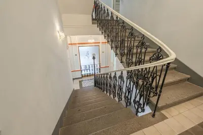 a stairway with a wrought iron spiral staircase at HOMELY I Central 28m2 loft I ELEVATOR I Self Check-In in Prague