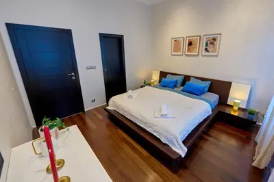 a bedroom with a large bed with blue pillows at Heart of Prague Stylish 3BR Apartment in Prague