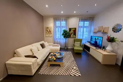 a living room with a white couch and a tv at Heart of Prague Stylish 3BR Apartment in Prague