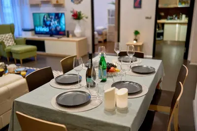 a table with plates and wine glasses on it at Heart of Prague Stylish 3BR Apartment in Prague