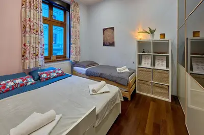 a small bedroom with two beds and a window at Heart of Prague Stylish 3BR Apartment in Prague