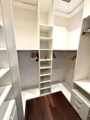 a walk in closet with white cabinets and wooden floors at Heart of Prague Stylish 3BR Apartment in Prague