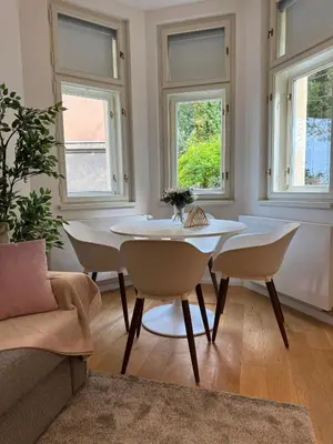 a white dining room with a table and chairs at Modern Luxury Apartment with Garden in Prague
