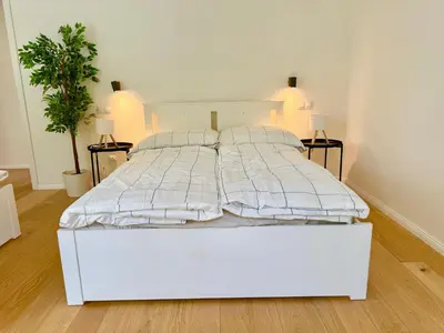 a white bed in a bedroom with two plants at Modern Luxury Apartment with Garden in Prague