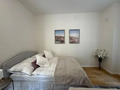a bedroom with a bed with three pictures on the wall at Modern Luxury Apartment with Garden in Prague