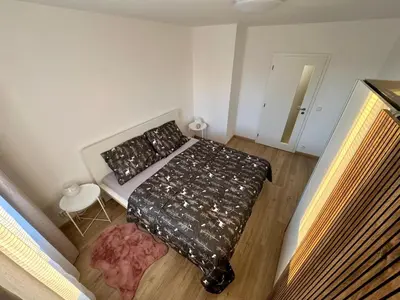 a small bedroom with a bed and a chair at FH Apartment Letňany in Prague