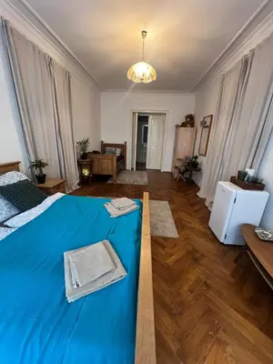 a bedroom with a blue bed and a living room at štepánská noc B in Prague