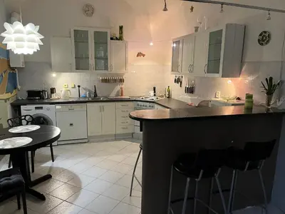 a kitchen with white cabinets and a black counter top at Apartmán LACRON Praha in Prague