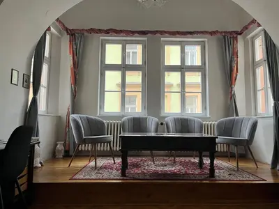 a dining room with a table and chairs and windows at Apartmán LACRON Praha in Prague