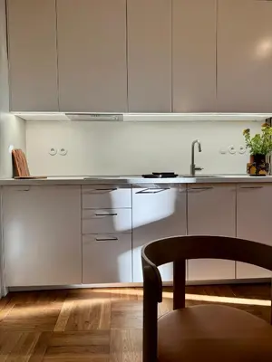 a kitchen with white cabinets and a chair and a sink at Old Soul,New Style,Best location in Prague