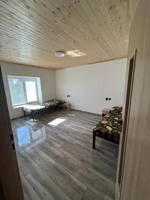 an empty room with two beds and a wooden ceiling at House in Čakovice near Štětí in Štětí