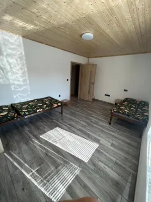 an empty room with two beds and a wooden floor at House in Čakovice near Štětí in Štětí