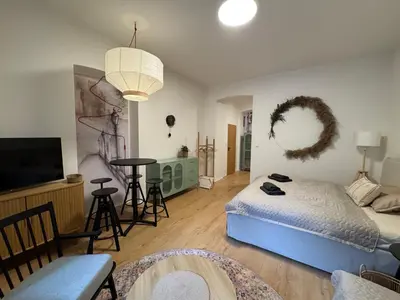 a bedroom with a bed and a living room at Prague Apartment Tomani in Prague