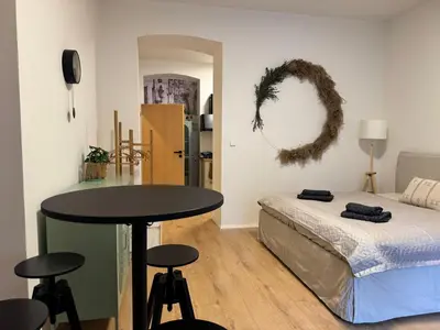 a bedroom with a bed and a table and stools at Prague Apartment Tomani in Prague