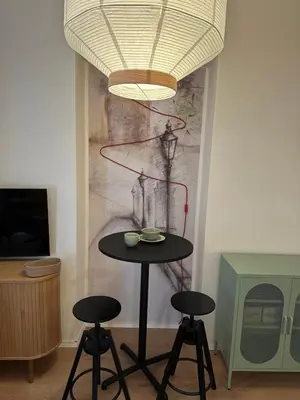a table and two stools in a room with a painting at Prague Apartment Tomani in Prague