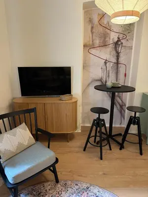 a living room with a tv and a table and chairs at Prague Apartment Tomani in Prague