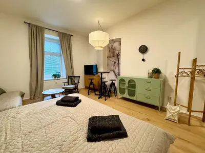 a bedroom with a large bed and a living room at Prague Apartment Tomani in Prague