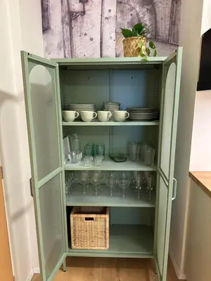 a green cabinet with cups and dishes in it at Prague Apartment Tomani in Prague