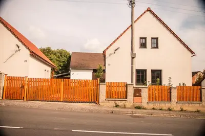 an orange fence in front of a white house at Garage u Barbory in Rakovník