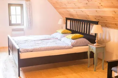 a bed in a bedroom with a wooden ceiling at Garage u Barbory in Rakovník