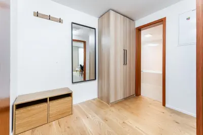 a room with a mirror and a wooden door at Rentero Modern Prague Smichov Apartment with Balcony in Prague