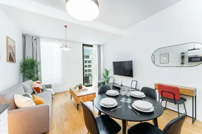 a living room with a black table and chairs at Rentero Modern Prague Smichov Apartment with Balcony in Prague