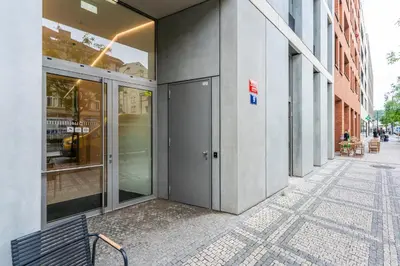 a building with a door on the side of a street at Rentero Modern Prague Smichov Apartment with Balcony in Prague