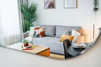 a living room with a couch and a table at Rentero Modern Prague Smichov Apartment with Balcony in Prague