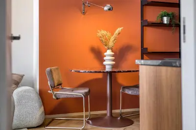 a table and two chairs in a room with an orange wall at Boutique Apartment - 2 Double Beds and Balcony in City Centre by Gravity Prague in Prague