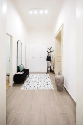 a living room with white walls and wood floors at Prague Days - Apartments with AC in Vinohrady in Prague