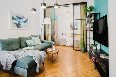 a living room with a couch and a tv at Prague Days - Two Bedroom Apartment with AC next to National Theatre in Prague