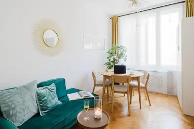 a living room with a green couch and a table at Prague Days - Two Bedroom Apartment with AC next to National Theatre in Prague