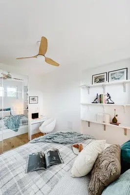 a white bedroom with a bed and a ceiling fan at Prague Days - One Bedroom Apartment with AC and Workspace in Holešovice in Prague