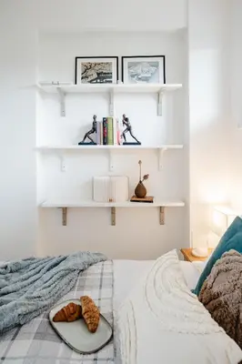 a bedroom with white shelves and a bed with a plate of food at Prague Days - One Bedroom Apartment with AC and Workspace in Holešovice in Prague